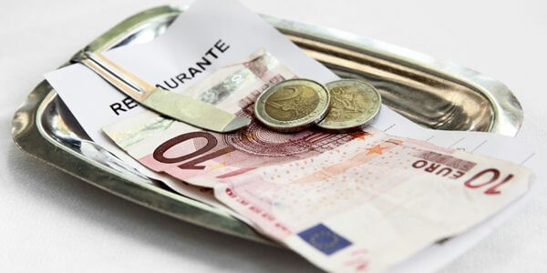 Conta de restaurante com moedas e notas em euros Conta de restaurante com moedas e notas em euros
